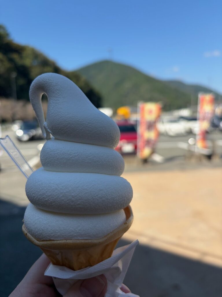 道の駅マキノ追坂峠で買った米粉ソフトクリーム。うしろに山と駐車場