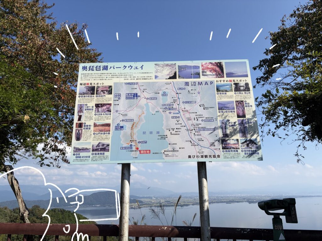 つづら尾崎展望台に立つ奥琵琶湖パークウェイの周辺マップの看板。白いペンのイラストつき